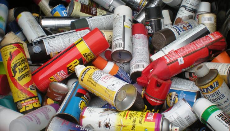 Photo of used aerosol cans in trash